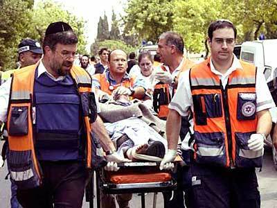 Emergency personnel evacuate one of the wounded from the scene of the explosion at Hebrew University of Jerusalem.