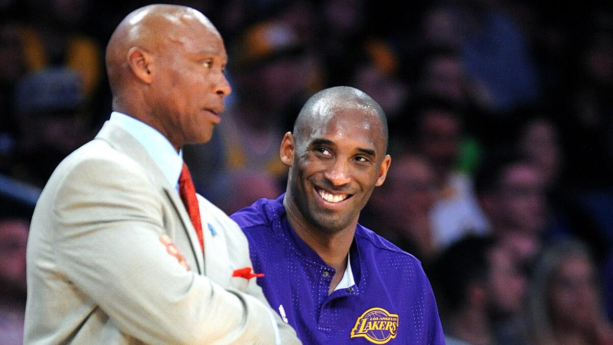 Lakers coach Byron Scott chats with guard Kobe Bryant during a game.