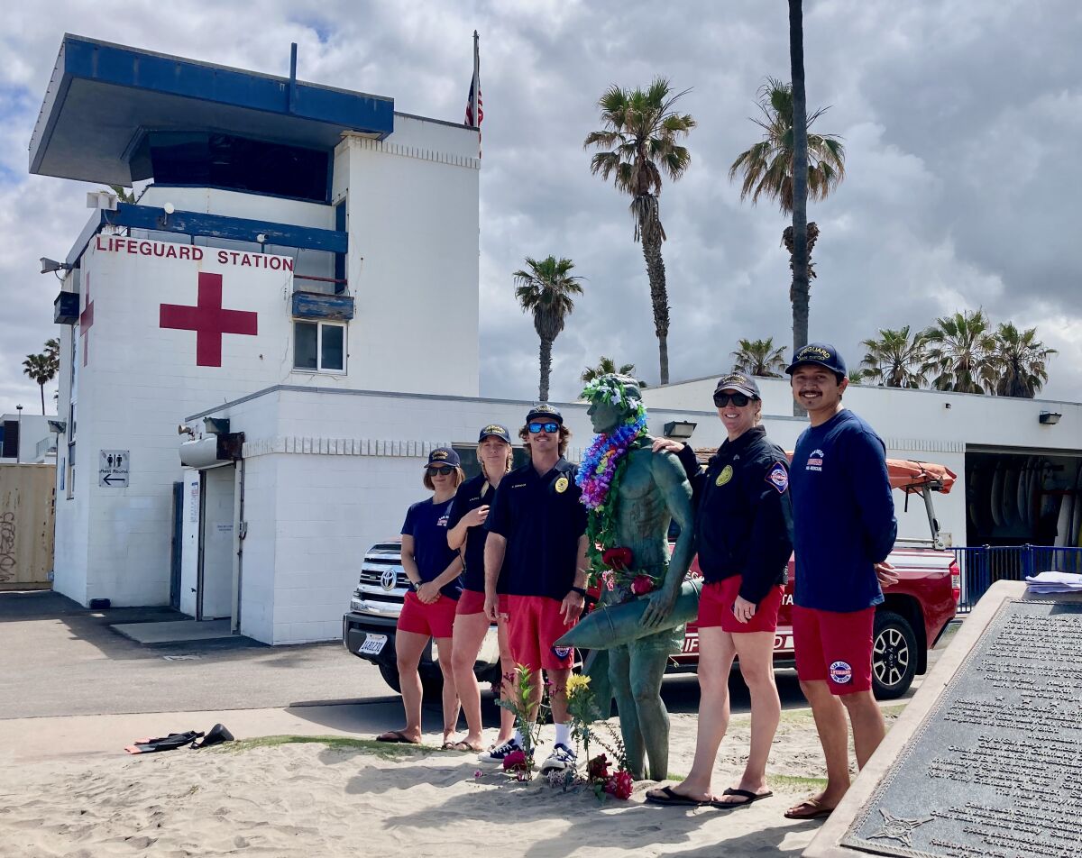 Ocean Beach lifeguards stand with OB's lifeguard statue on May 5 this year.