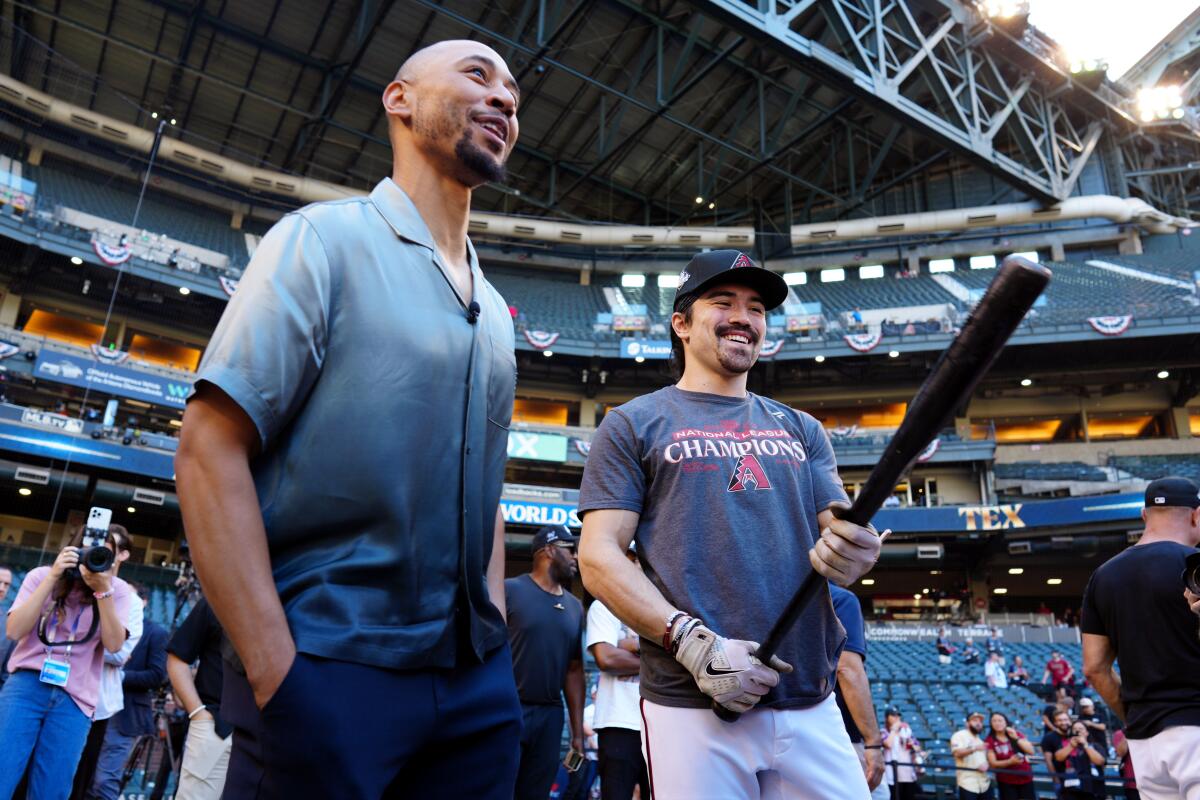 Mookie Betts jokes with Corbin Carroll of the Arizona Diamondbacks during batting practice on Oct. 30, 2023, in Phoenix.