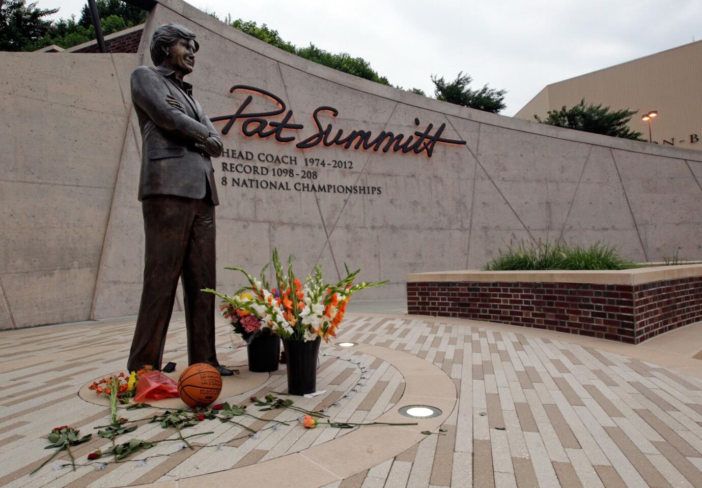 Flowers lay alongside a memorial basketball fans have left at the Pat Summitt statue Tuesday, June 28, 2016, in Knoxville, Tenn.