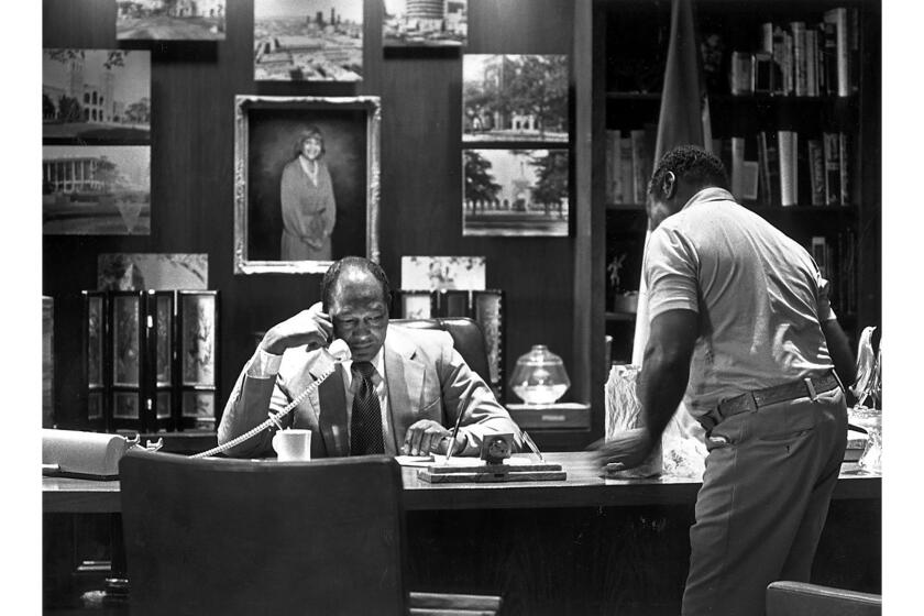 Sept. 18, 1990: During his monthly open house, Los Angeles Mayor Tom Bradley takes a phone call in his office as a visiting citizen, William Gentry, waits.