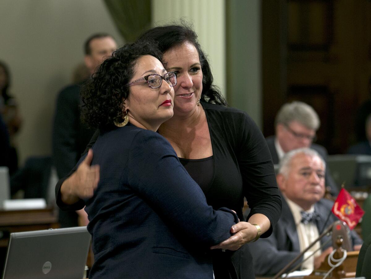 Democratic Assemblywomen Cristina Garcia, of Bell Gardens, left, and Lorena Gonzalez-Fletcher, of San Diego, watch as the votes are posted for Garcia's climate change bill on Monday in Sacramento.