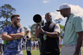 Baseball great Ken Griffey Jr., center, speaks with former NFL player Ryan Fitzpatrick, left, and a patron at the Masters