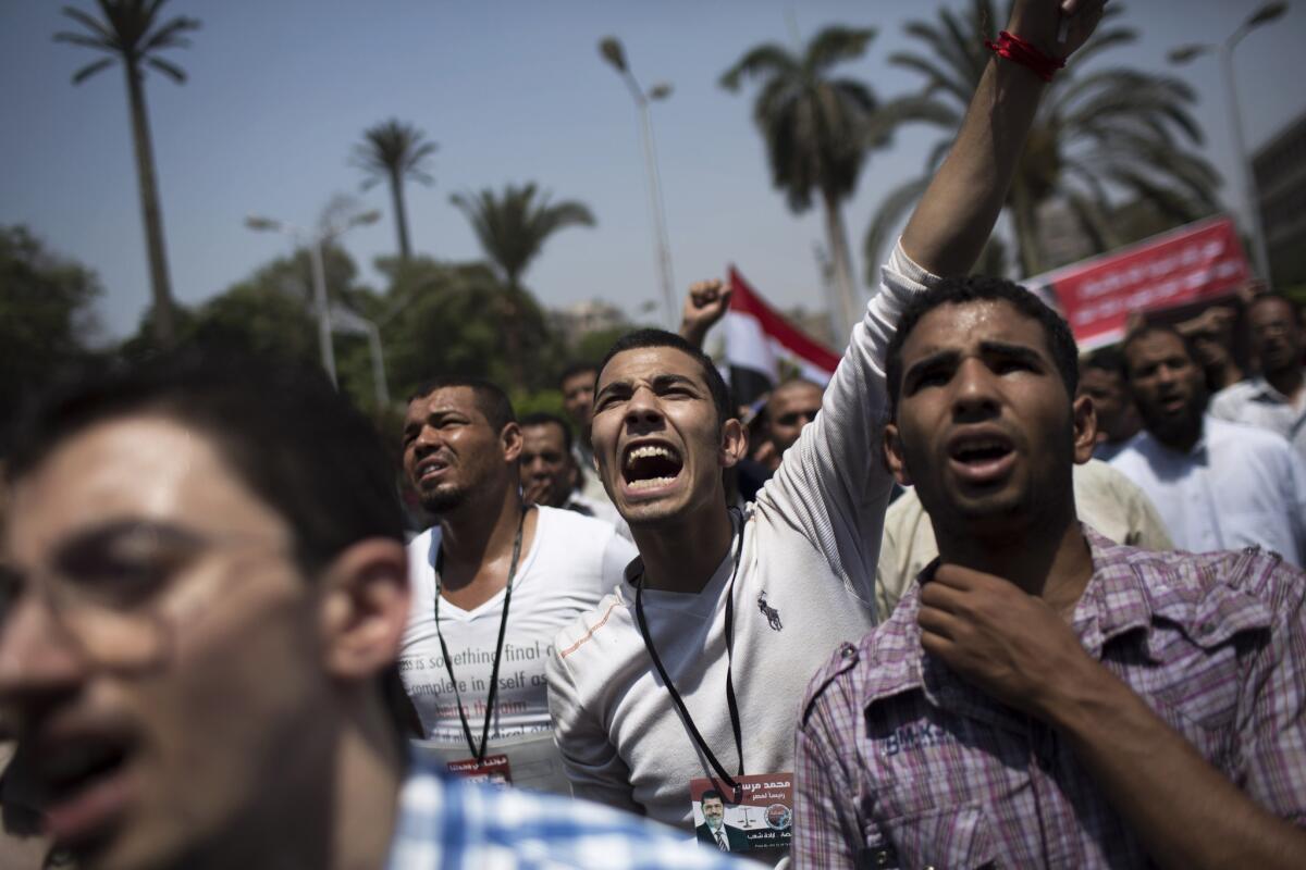 Supporters of Egypt's ousted president, Mohamed Morsi, chant slogans against the military near Cairo University.
