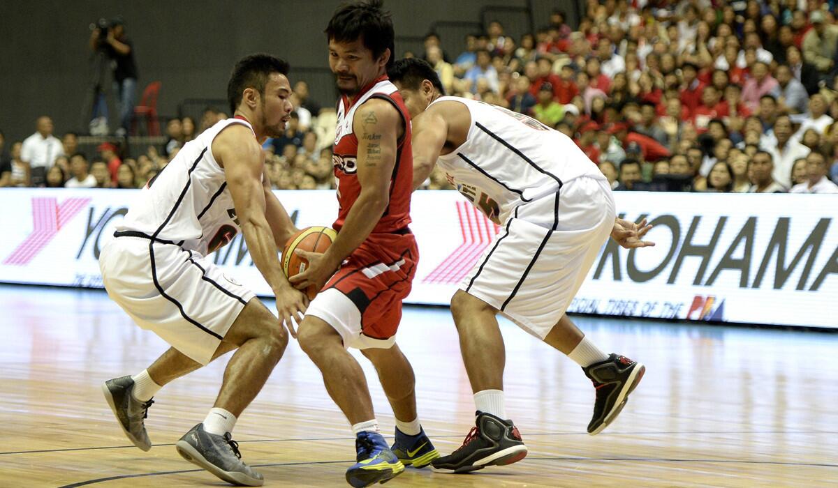 Kia Sorento player-coach Manny Pacquiao tries to split the double-team defense of Blackwater Elite during his pro basketball debut on Oct. 19.