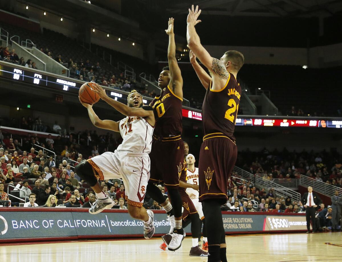 USC guard Jordan McLaughlin (11) drives to the basket against Arizona State guard Tra Holder (0) and forward Eric Jacobsen (21) in the first half at Galen Center on Thursday.