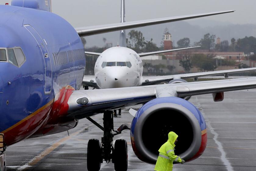 LOS ANGELES, CALIF. DEC. 22, 2016. Jetliners line up to park at gates in Terminal 1 at LAX on Thursday, Dec. 22, 2016, one of the busiest travel days of the year. Inclement weather caused dozens of flights to and from LAX to be delayed or canceled on Thursday. (Luis Sinco/Los Angeles Times)