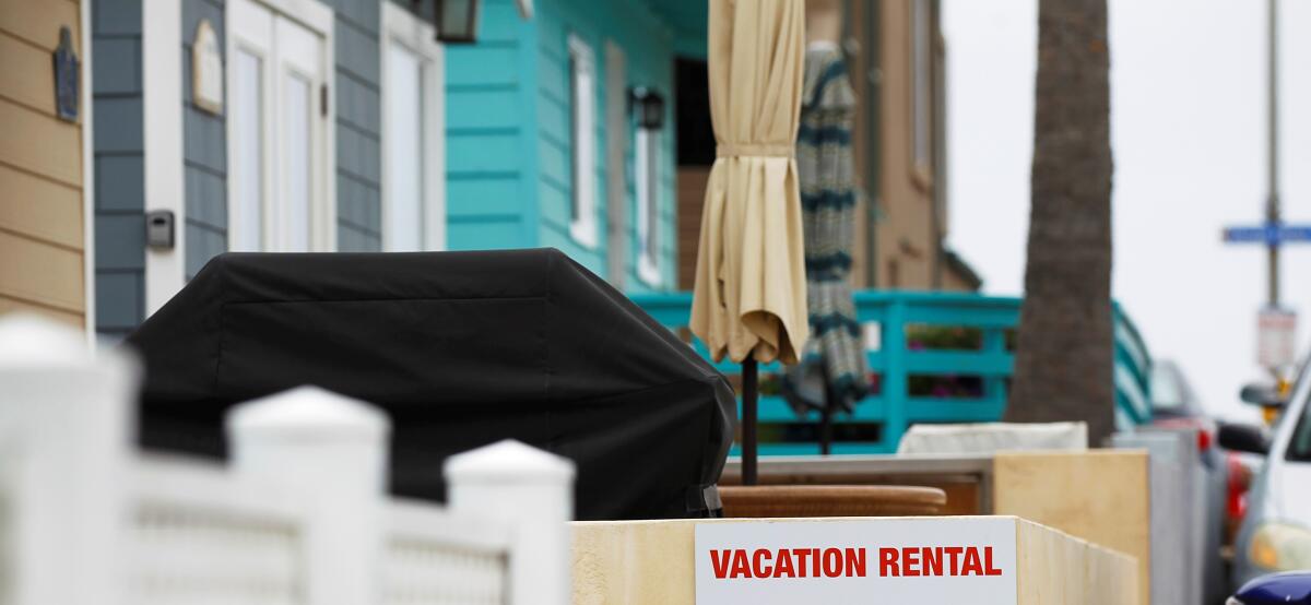 A vacation rental sign hangs outside of a home.