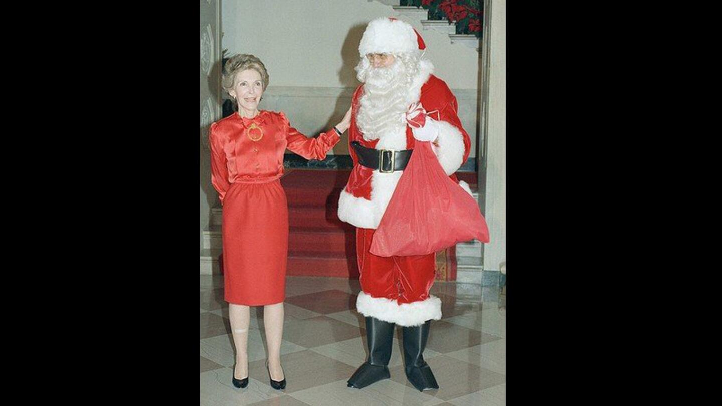 First Lady Nancy Reagan is accompanied by television personality Ed McMahon as Santa during a 1987 press tour of the White House Christmas décor.