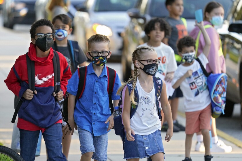 FILE - In this Tuesday, Aug. 10, 2021 file photo, Students, some wearing protective masks, arrive for the first day of school at Sessums Elementary School in Riverview, Fla. President Joe Biden has called school district superintendents in Florida and Arizona, praising them for doing what he called “the right thing” after their respective boards implemented mask requirements in defiance of their Republican governors amid growing COVID-19 infections. (AP Photo/Chris O'Meara, File)
