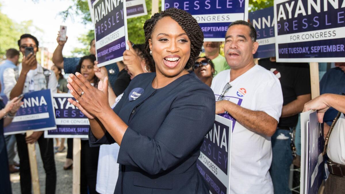 Ayanna Pressley applauds in front of her supporters on primary day in Chelsea, Mass.