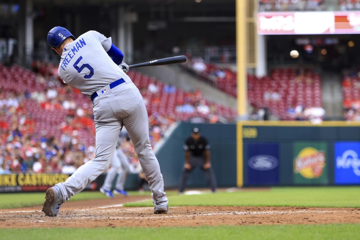 Dodgers' Freddie Freeman hits an RBI single against the Cincinnati Reds.