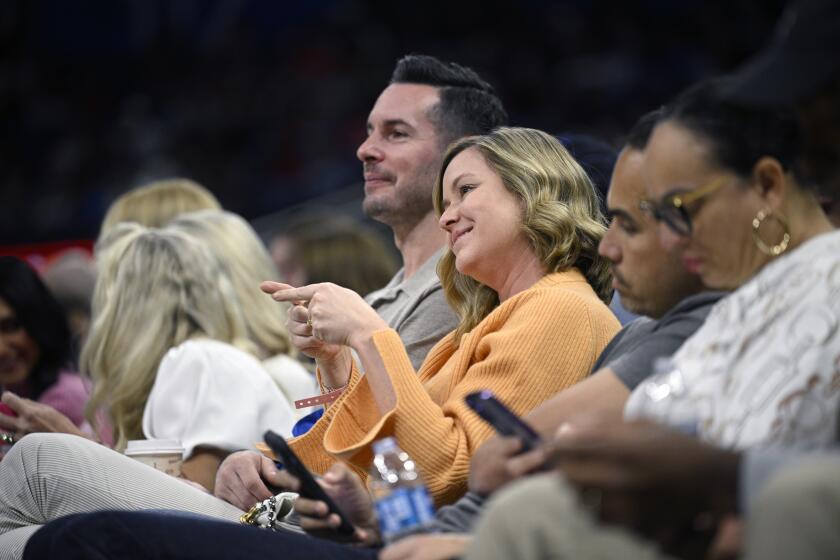 Former Orlando Magic guard JJ Redick, center, and his wife, Chelsea Kilgore, third from right, watch from court side seats during the second half of an NBA basketball game against the New York Knicks, Wednesday, Feb. 14, 2024, in Orlando, Fla. (AP Photo/Phelan M. Ebenhack)