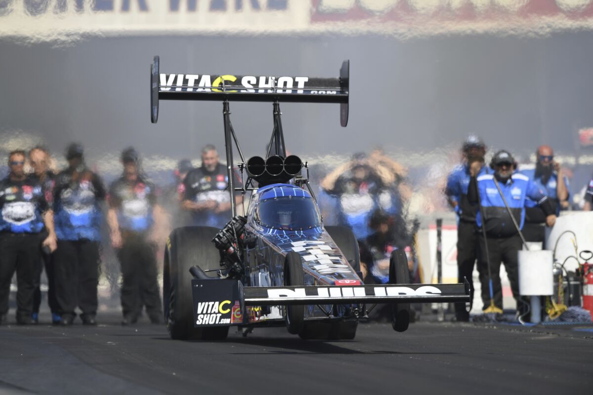 In this photo provided by the NHRA, Top Fuel star Justin Ashley takes home the NHRA Wally trophy.