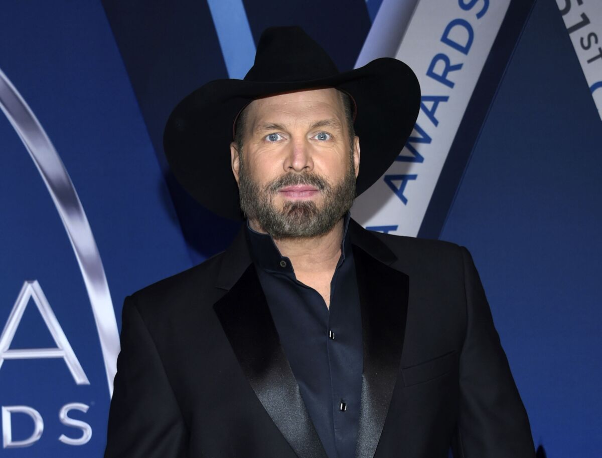 Garth Brooks in a black suit with a black cowboy hat