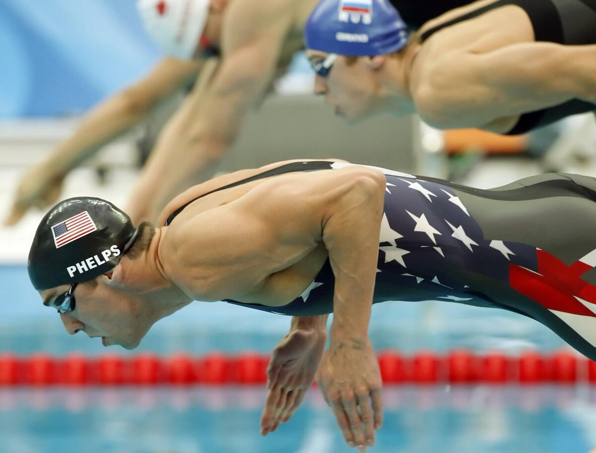 U.S. swimmer Michael Phelps jumps out of the starting block in a full-body performance-enhancing suit for the first leg of the men's 4x200 freestyle relay at the 2008 Beijing Olympics.