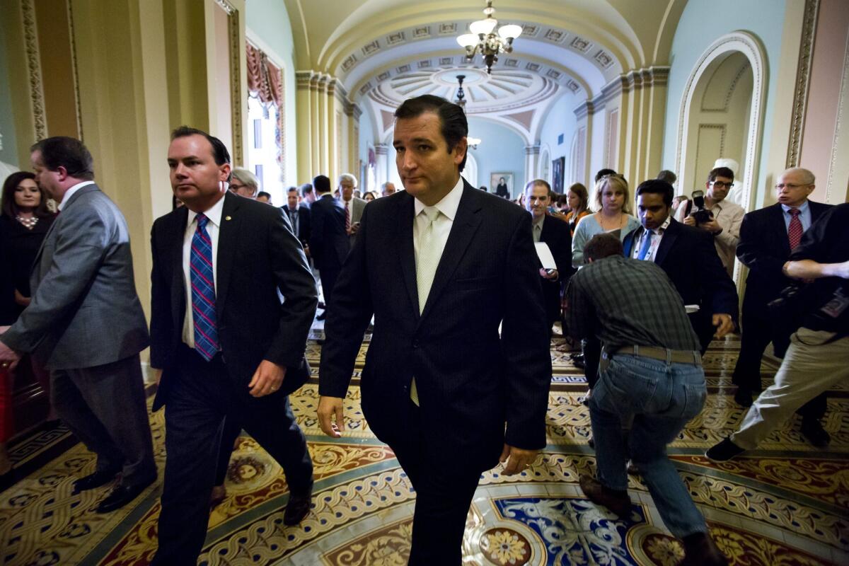 Sens. Ted Cruz (R-Texas) and Mike Lee (R-Utah) depart a news conference in the Capitol on Friday after the Senate passed a temporary budget bill without defunding the Patient Protection and Affordable Care Act.