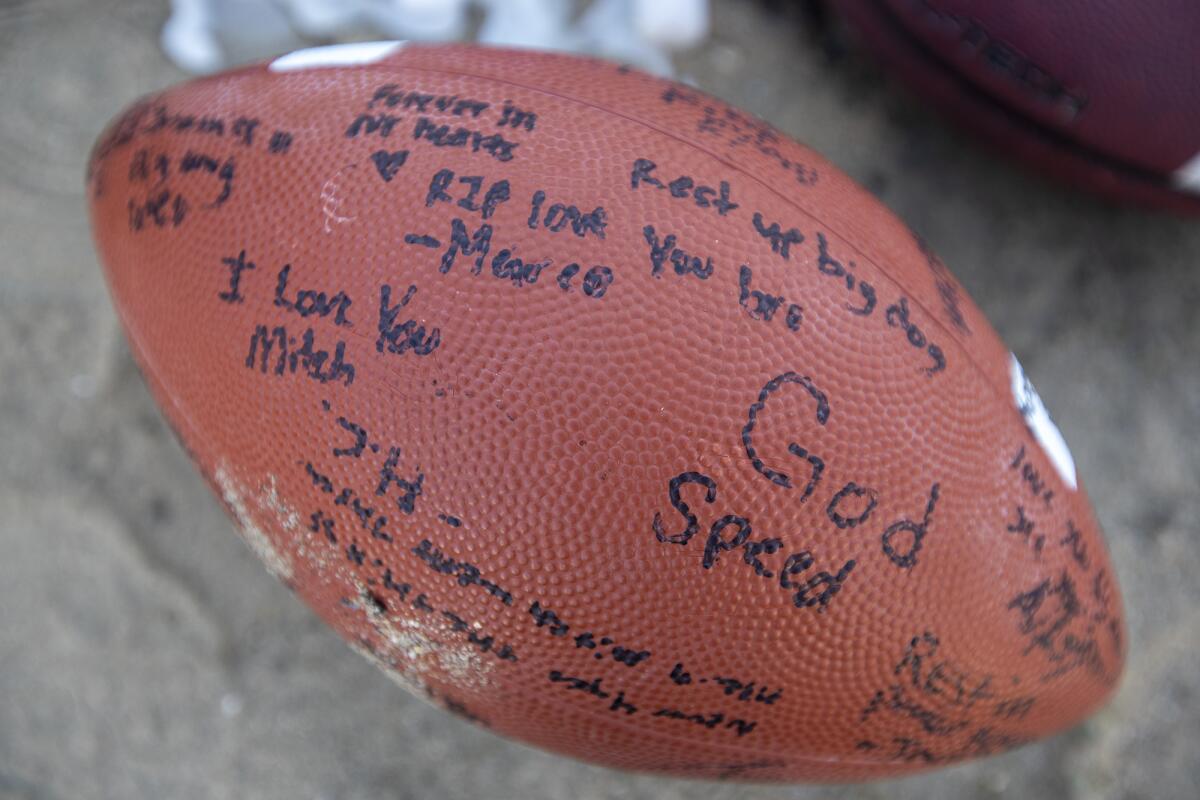 A signed football is among the items at a roadside shrine for 19-year-old Mitchell Tyler Wade.