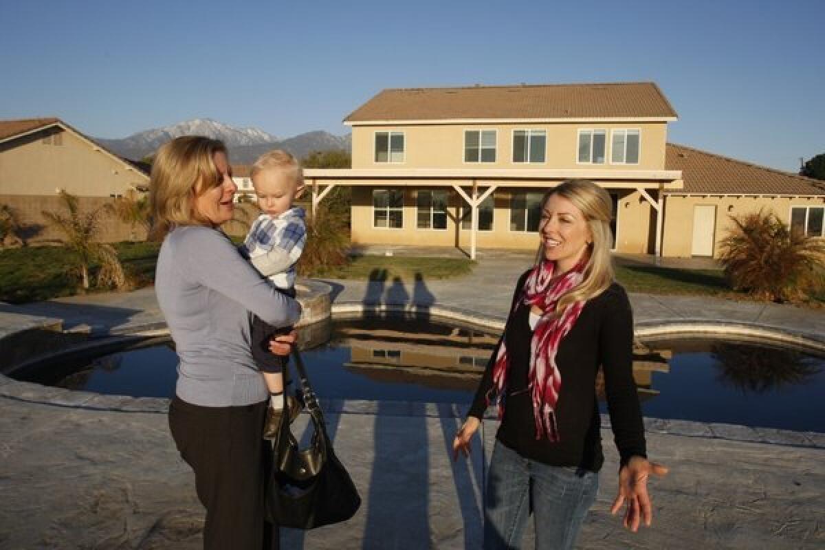 Shannon Bridgewater, right, with her son Brayden, and real estate agent Carey Chenoski check out a house in Yucaipa this year. The Inland Empire is reemerging as a home-building hot spot.