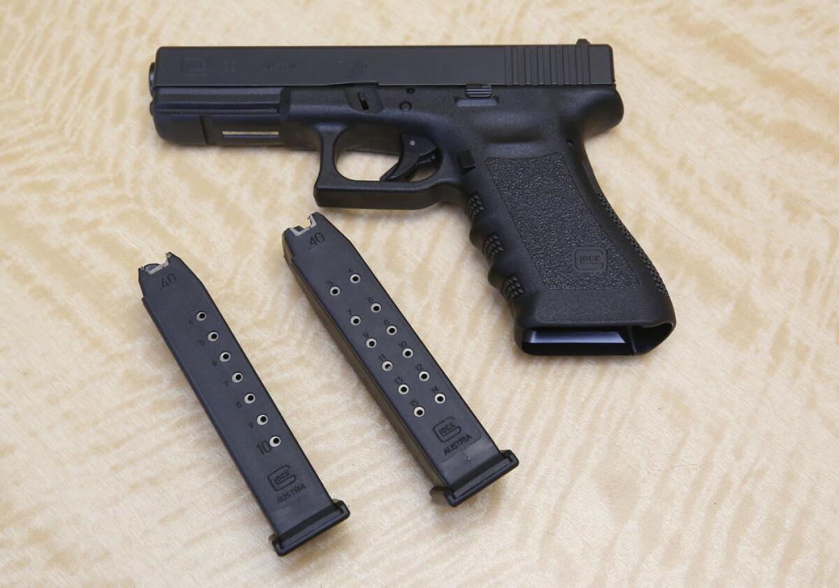 A handgun is displayed with 10- and 15-shot magazines.