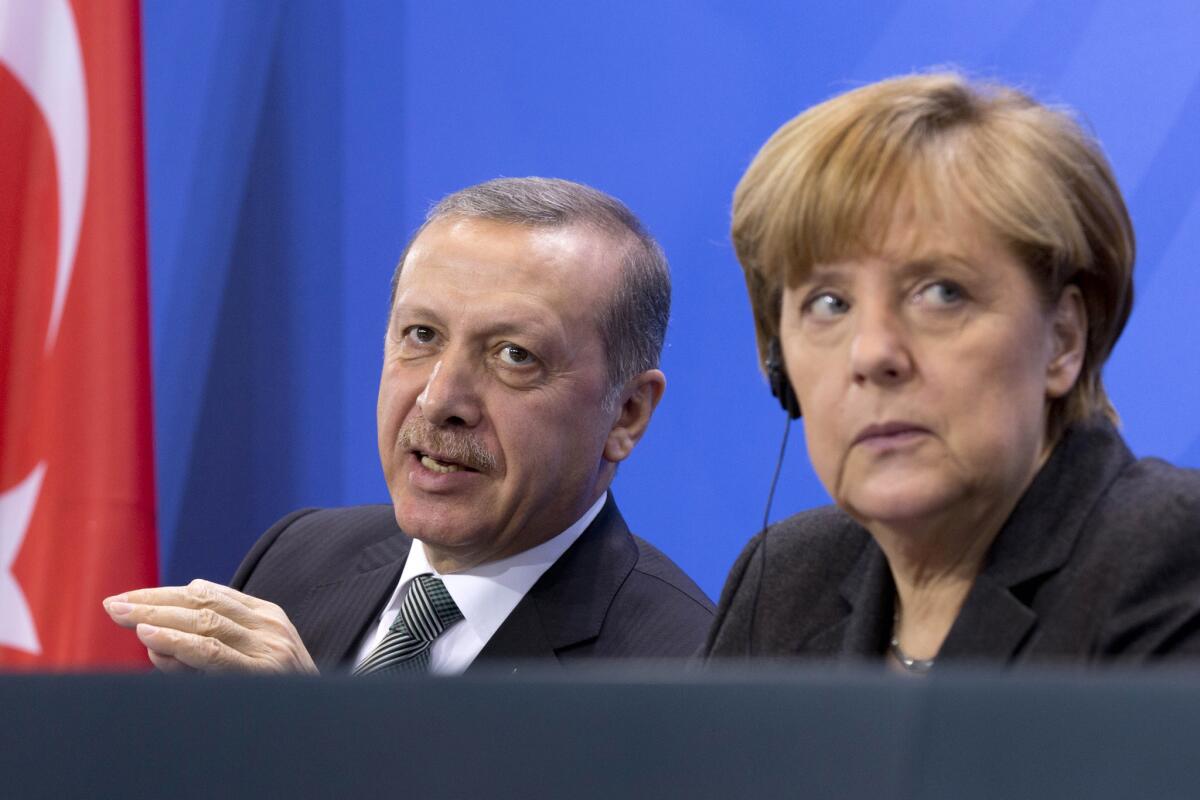 In this Feb. 4 file picture, German Chancellor Angela Merkel listens to Turkish President Recep Tayyip Erdogan during a joint news conference after a meeting in Berlin.