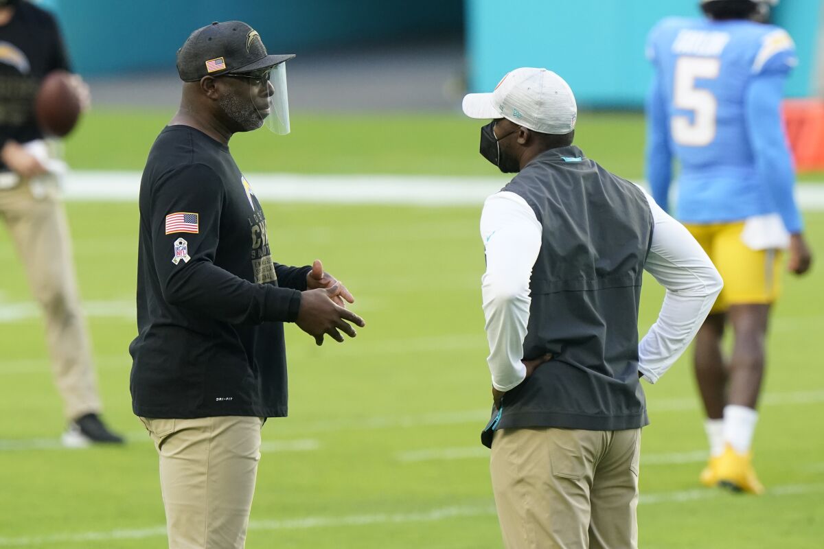 Chargers coach Anthony Lynn, left, talks to Miami Dolphins coach Brian Flores before Sunday's game.