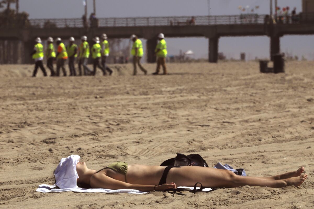 A sunbather enjoys the day at Huntington Beach on Saturday.