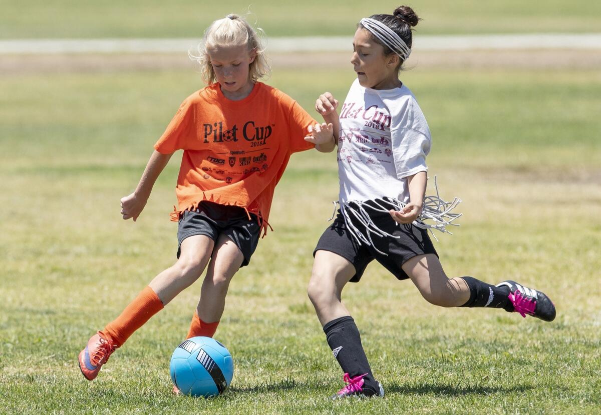 Davis Elementary's Savannah Roy, left, and Sonora Elementary's Caylin Caro battle for a ball during a girls' fifth- and sixth-grade Bronze Division quarterfinal match at the Daily Pilot Cup in Costa Mesa on June 2, 2018.