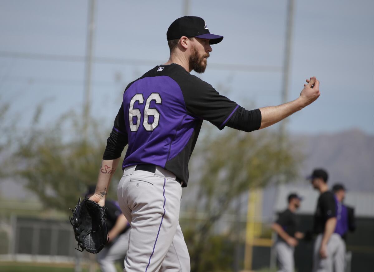Colorado pitcher John Axford participates in a drill during spring training Feb. 21 in Scottsdale, Ariz.