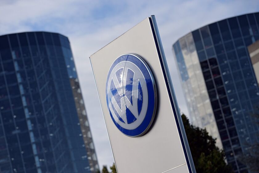 The Volkswagen logo is seen in front of the storage towers of the company's "Autostadt" (car city) in Wolfsburg, Germany.