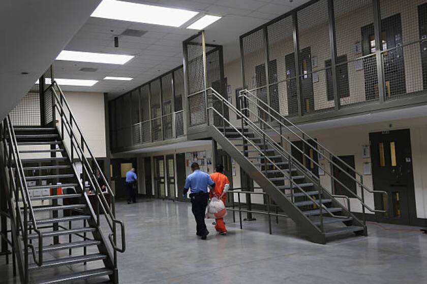 ADELANTO, CA - NOVEMBER 15: A guard escorts an immigrant detainee from his 'segregation cell' back into the general population at the Adelanto Detention Facility on November 15, 2013 in Adelanto, California. Most detainees in segregation cells are sent there for fighting with other immigrants, according to guards. The facility, the largest and newest Immigration and Customs Enforcement (ICE), detention center in California, houses an average of 1,100 immigrants in custody pending a decision in their immigration cases or awaiting deportation. The average stay for a detainee is 29 days. The facility is managed by the private GEO Group. ICE detains an average of 33,000 undocumented immigrants in more than 400 facilities nationwide. (Photo by John Moore/Getty Images)