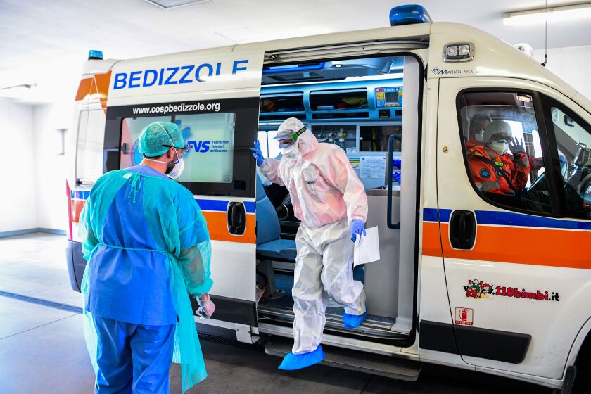 A medical worker wearing a face mask brings a patient in an ambulance arriving at the new coronavirus intensive care unit of the Brescia Poliambulanza hospital, Lombardy, on March 17, 2020. (Photo by Piero CRUCIATTI / AFP) (Photo by PIERO CRUCIATTI/AFP via Getty Images)