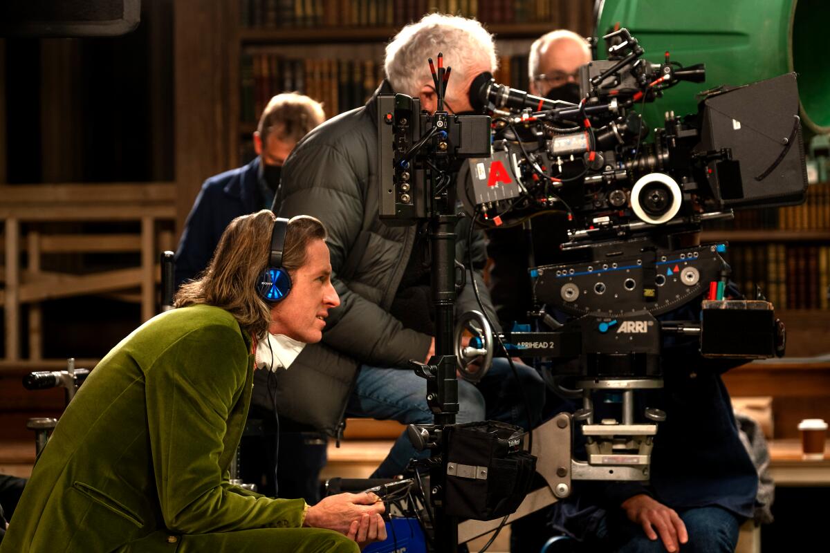 Wes Anderson sits next to the camera on the set of "The Wonderful Story of Henry Sugar."
