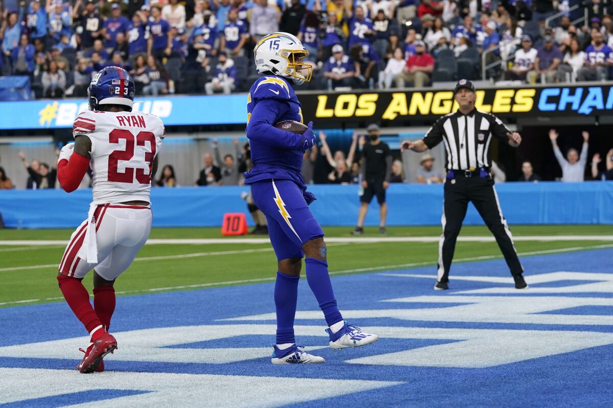 Los Angeles Chargers wide receiver Jalen Guyton (15) stands in the end zone after catching a touchdown past New York Giants safety Logan Ryan (23) during the first half of an NFL football game Sunday, Dec. 12, 2021, in Inglewood, Calif. (AP Photo/Gregory Bull)