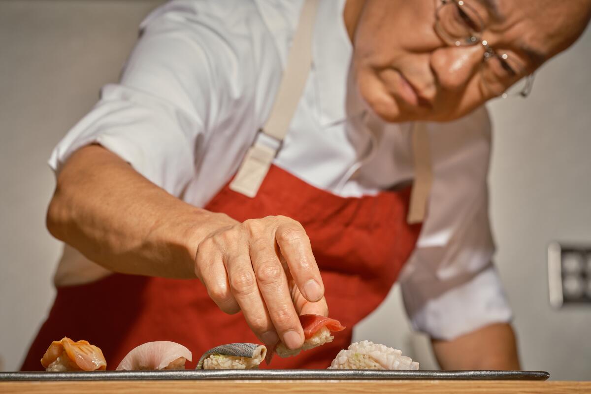 Chef-owner Morihiro Onodera places nigiri on a plate