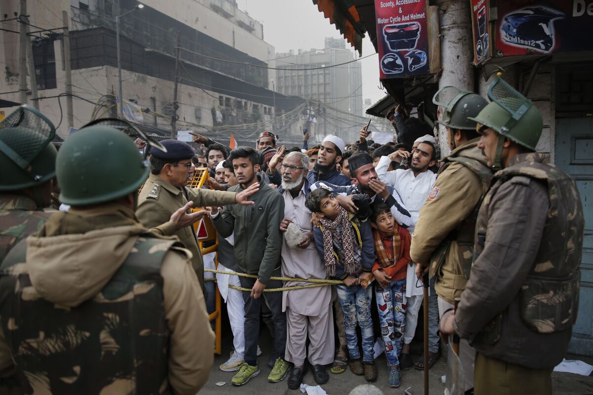Indian policemen stop protesters at a police barricade in New Delhi on Friday