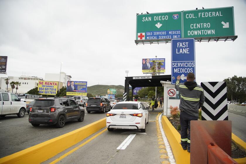 Tijuana, Baja California - February 29: Crossborder students will be allowed to use the "Fast Lane" at the San Ysidro port of entry, as part of a new Tijuana program. Officials and students hold a news event. Worker repairs a sign at Fast Lane entrance in Zona Rio on Thursday, Feb. 29, 2024 in Tijuana, Baja California. (Alejandro Tamayo / The San Diego Union-Tribune)