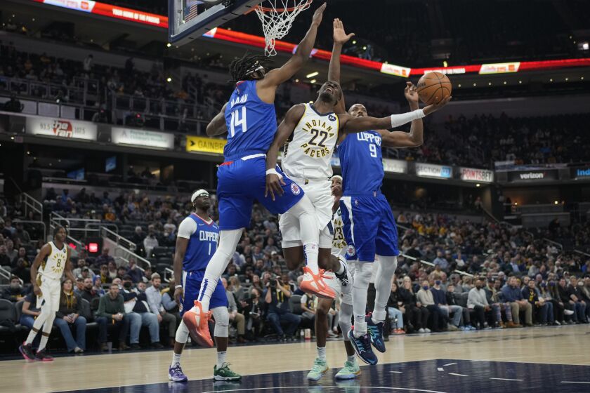 Indiana Pacers guard Caris LeVert (22) shotos between Los Angeles Clippers defenders Terance Mann (14) and Serge Ibaka (9) during the first half of an NBA basketball game in Indianapolis, Monday, Jan. 31, 2022. (AP Photo/AJ Mast)