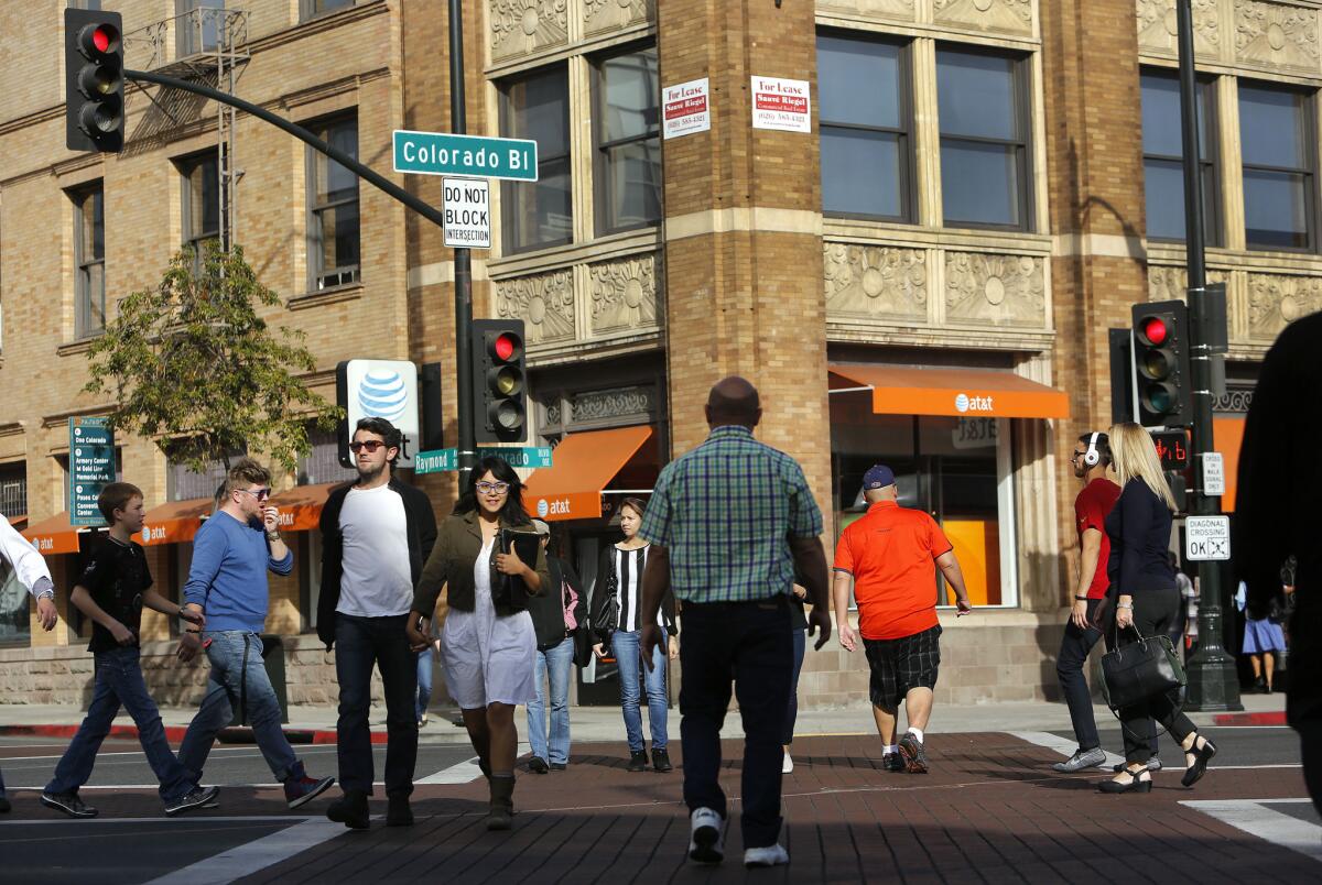 Pedestrians cross Colorado Boulevard in Pasadena. Walkable neighborhoods in older suburbs of Los Angeles are seeing increasing development, a new study says.