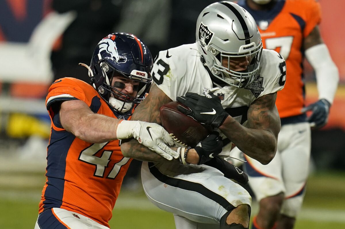 Denver Broncos inside linebacker Josey Jewell tackles Las Vegas Raiders tight end Darren Waller.