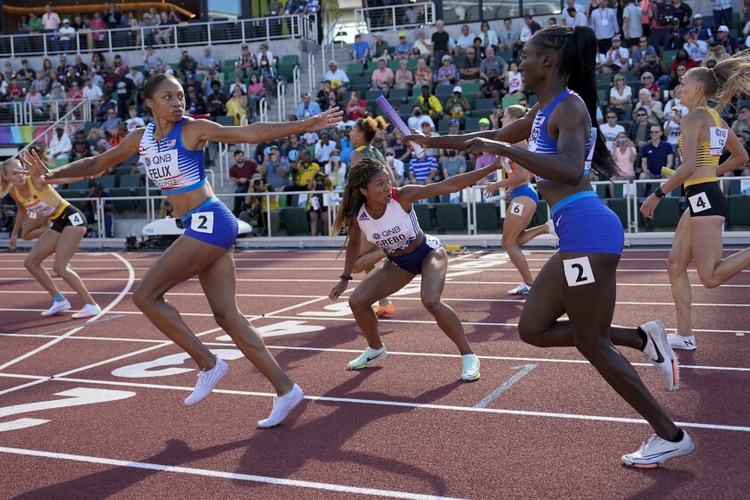Allison Felix takes the baton from Team USA colleague Talita Diggs during the women's 4x400m relay.