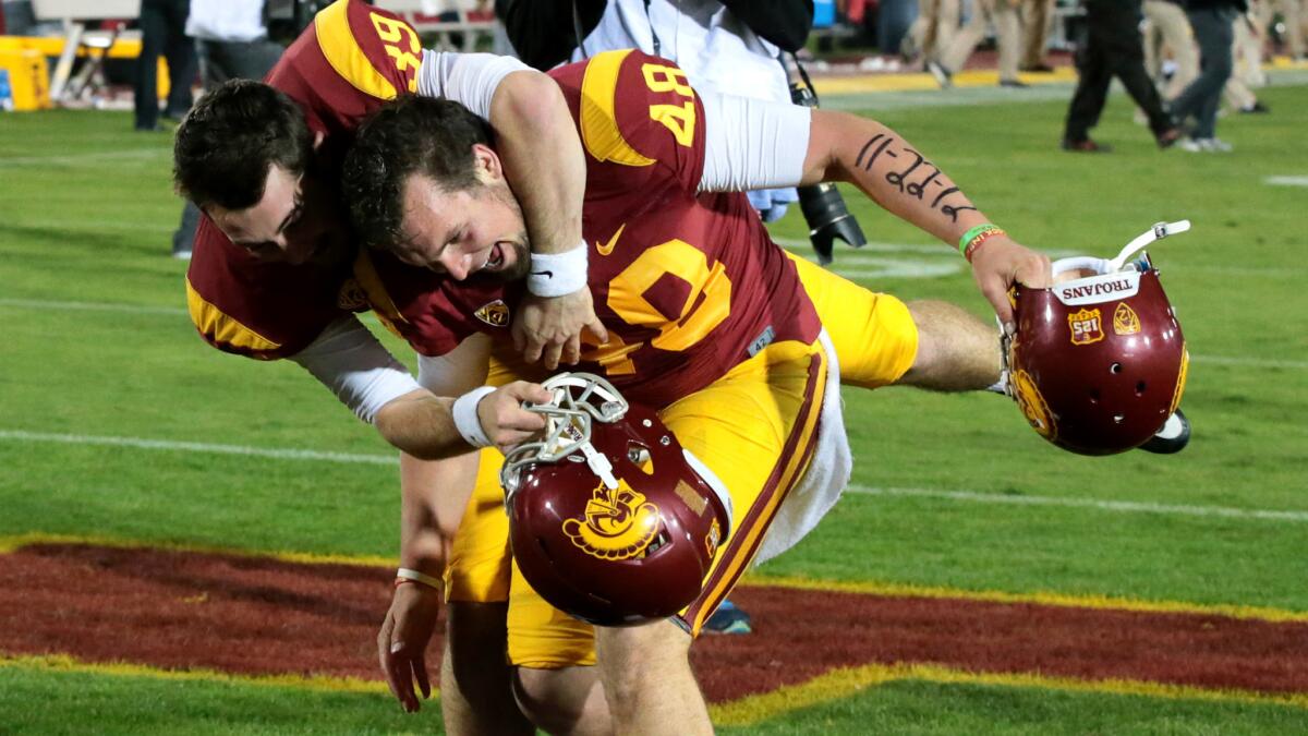 USC kicker Andre Heidari, who made a game-winning field goal, is mobbed by teammate Alex Wood after beating Stanford last season at the Coliseum. Wood is now the Trojans' kicker.