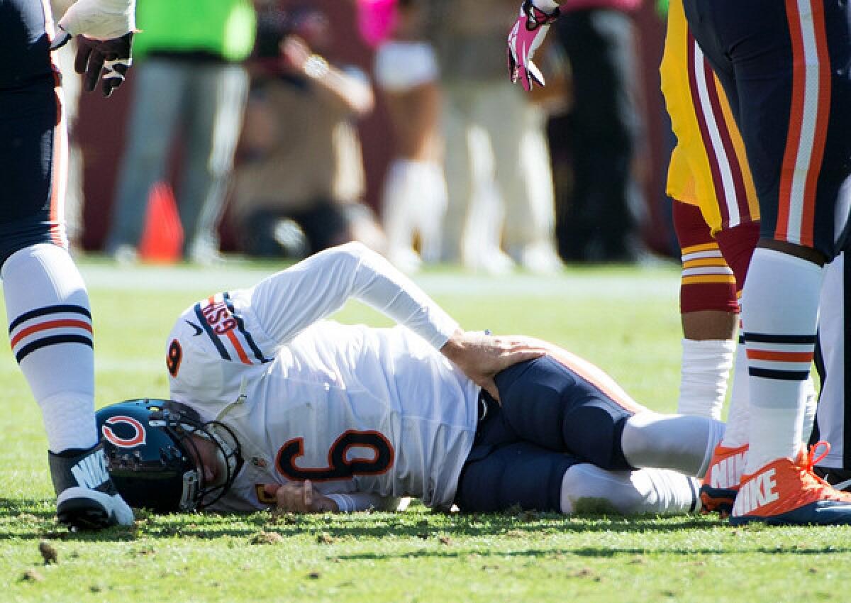 Bears quarterback Jay Cutler grabs his hip after getting sacked by Redskins nose tackle Chris Baker in the first half Sunday.