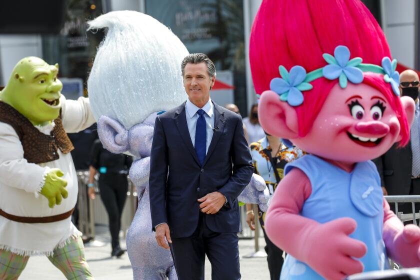 Universal City, CA - June 15: As part of California's full reopening, marking the end of pandemic-era restrictions like masks, social distancing and most capacity restrictions, Gov. Gavin Newsom enters alongside Universal Studios characers, including Shrek and Troll characters, before taking part in a press conference at Universal Studios, in Universal City, CA, Tuesday, June 15, 2021. Governor Newsom drew 10 winners to receive $1.5 million each, for a total of $15 million, as part of the final cash prize drawing in the state's $116.5 million Vax for the Win program - the largest vaccine incentive program in the nation. (Jay L. Clendenin / Los Angeles Times)