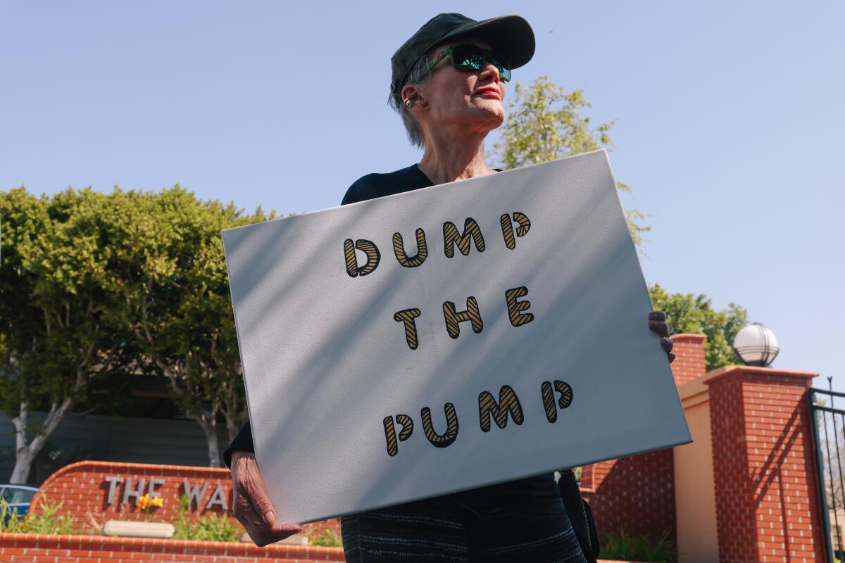An activist holds a "Dump the Pump" sign.