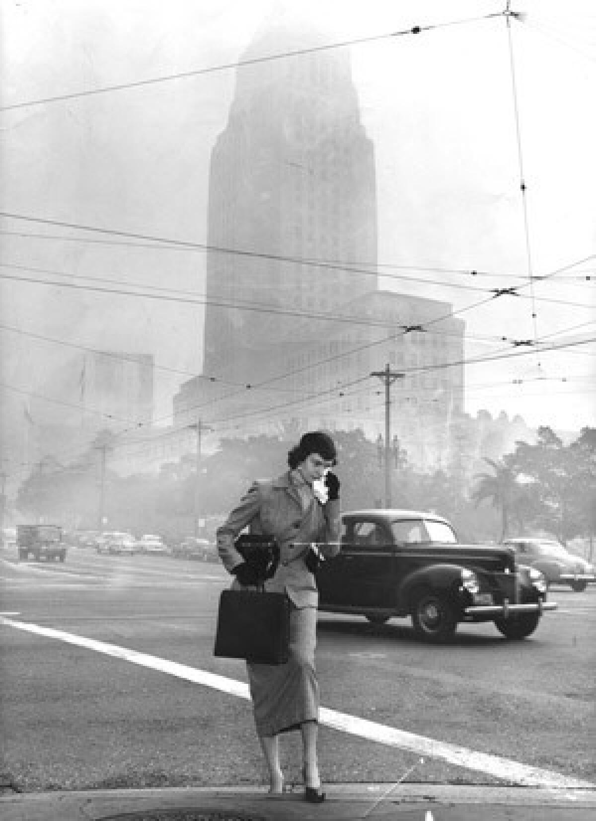 The smog near L.A. City Hall is so bad in 1953 that pedestrians carry rags to wipe tears.