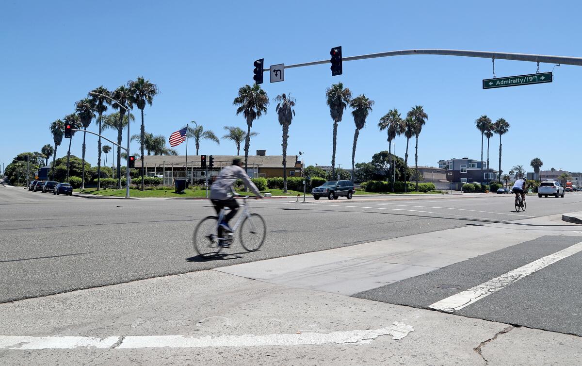 Two cyclists ride along East Pacific Coast Highway, at the intersection of Admiralty Drive and 19th Street, on Wednesday.