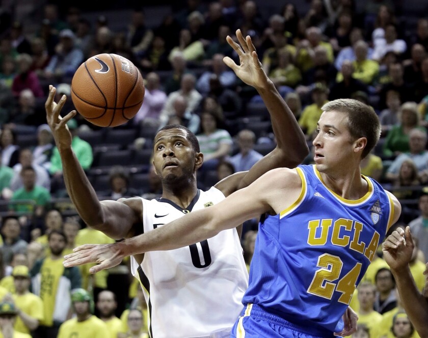 UCLA forward Travis Wear (24) and Oregon forward Mike Moser (0) battle for a rebound in the first half Thursday night in Eugene.