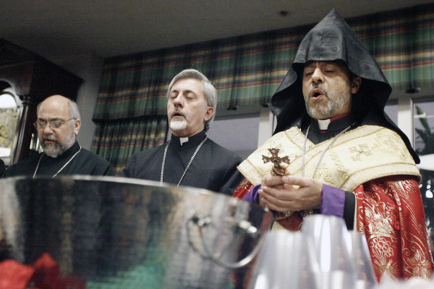 Father Sarkis Petoyan, from left, Father Hovsep Hagopian and Archbishop Hovnan Derderian sing a hymn before they bless the water and bread during an Armenian Christmas celebration, which took place at Glendale Adventist Medical Center on Thursday, January 5, 2012.